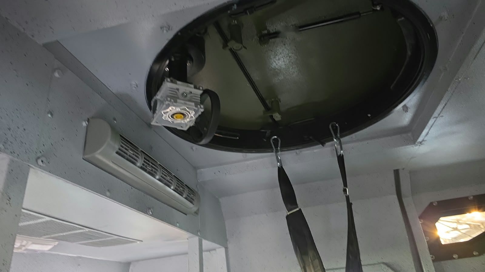 Escotilla circular superior y equipo de aire acondicionado en el techo interior de un vehículo blindado